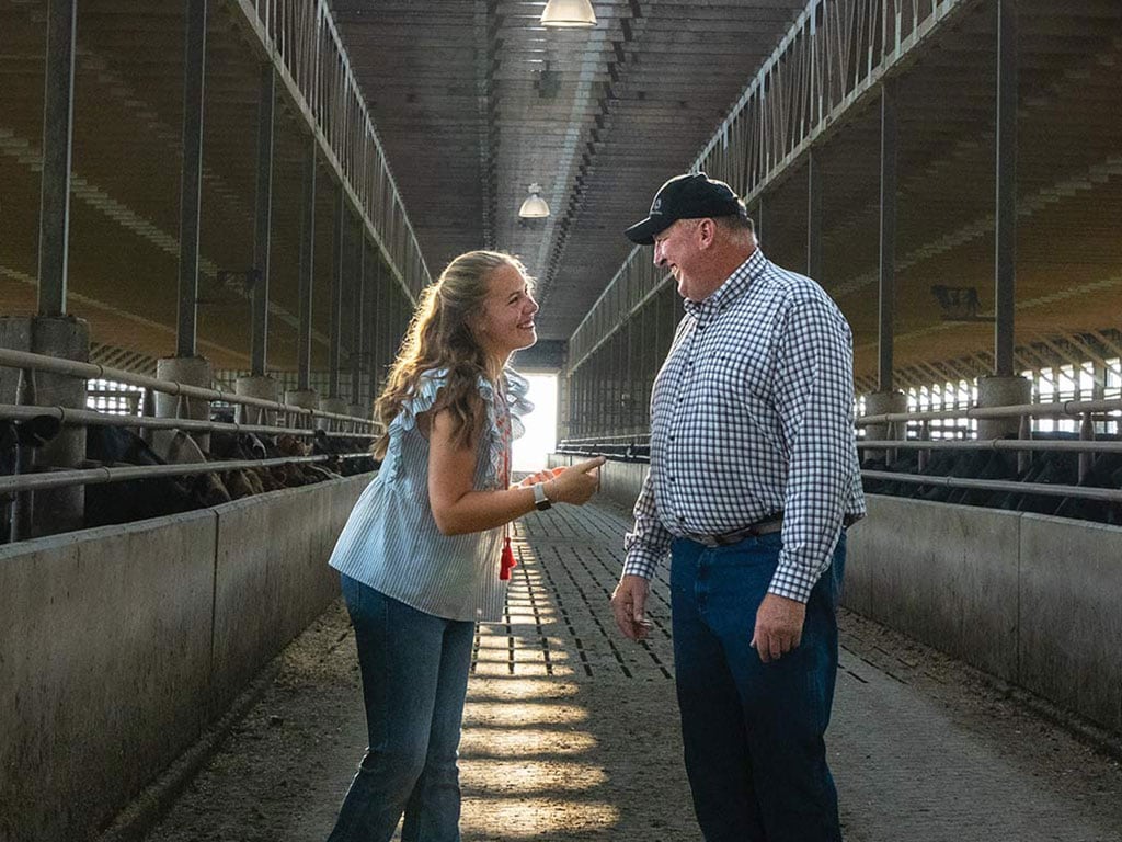 Deux agriculteurs qui se sourient dans une étable