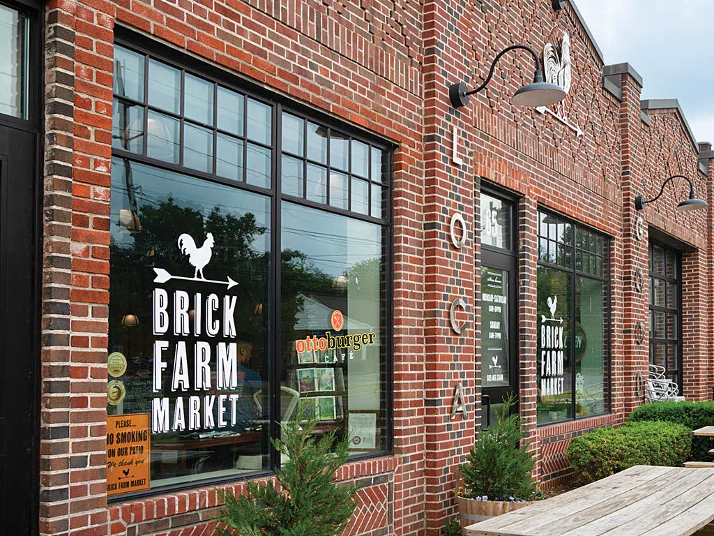 Brick Farm Market storefront with large windows and arched lamps