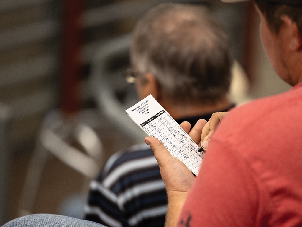 Person writing on paper during an auction