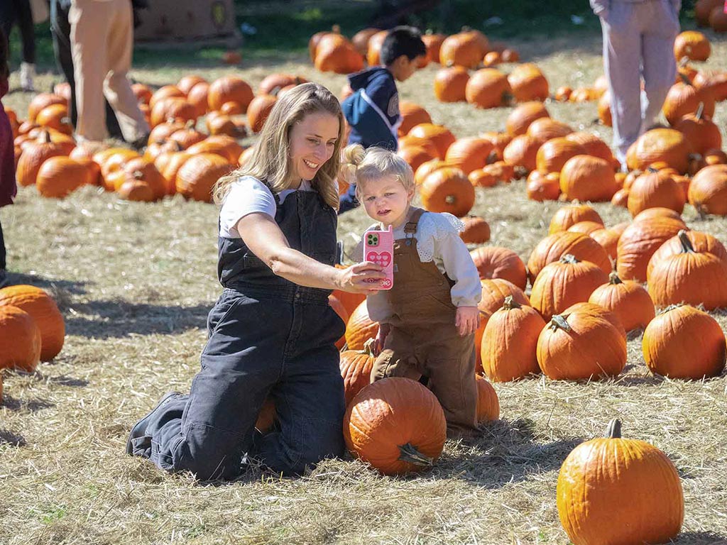 adults and children in a pumpkin patch