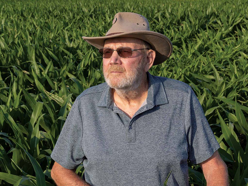 Person with wide brimmed hat and sunglasses on squinting into the distance