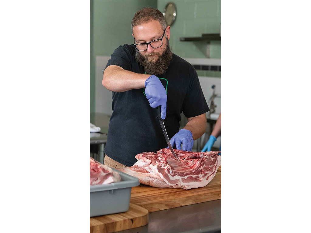 person slicing into side of pork