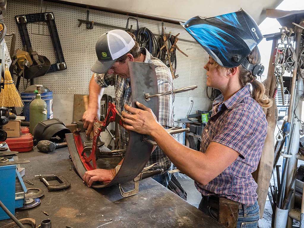 two people welding in a workshop