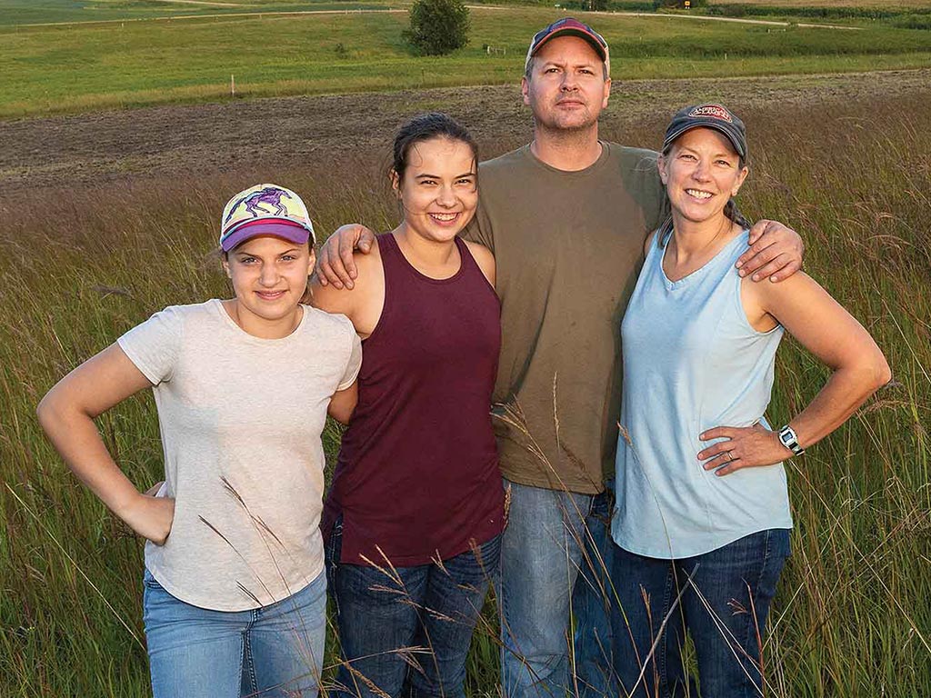 a farming family standing in a field