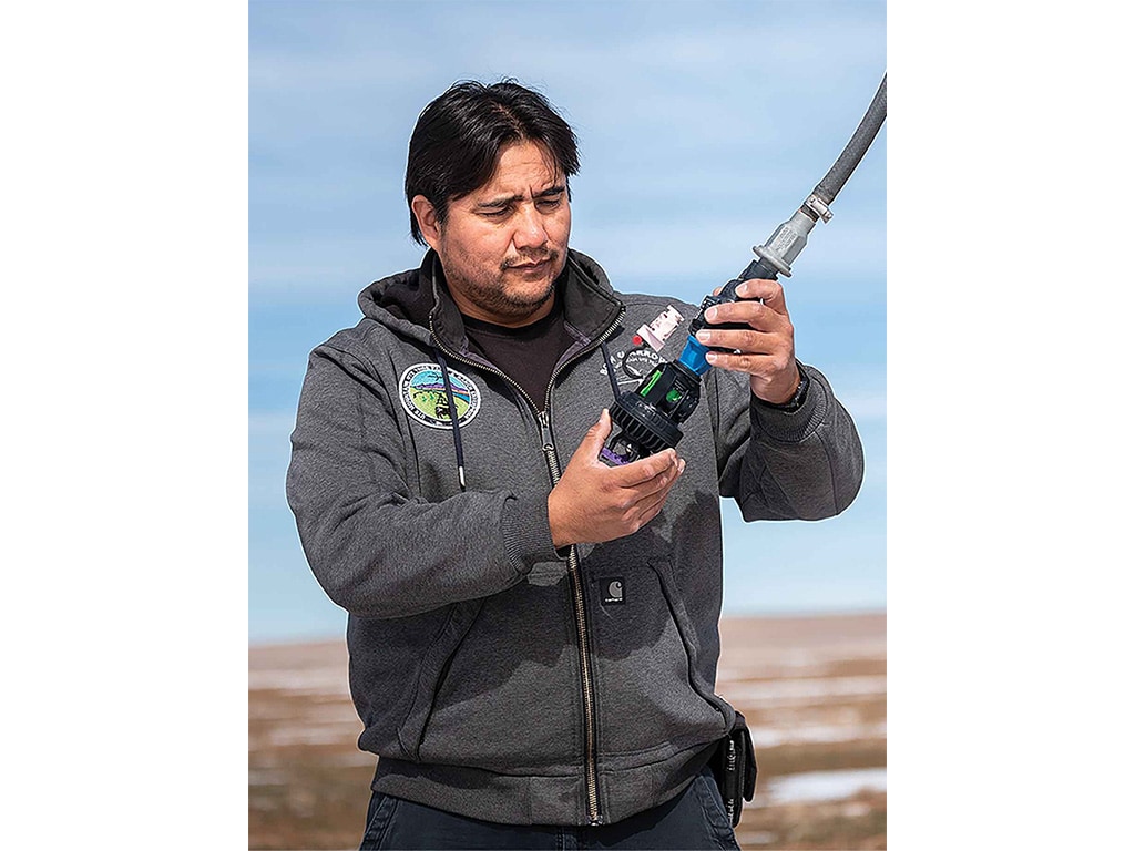 person inspecting an irrigation nozzle