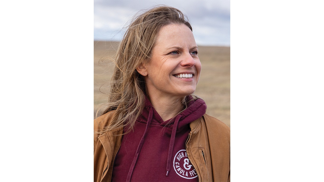 Person in maroon hoodie and brown jacket outdoors, text reads 'High Heels and Canola Fields'.
