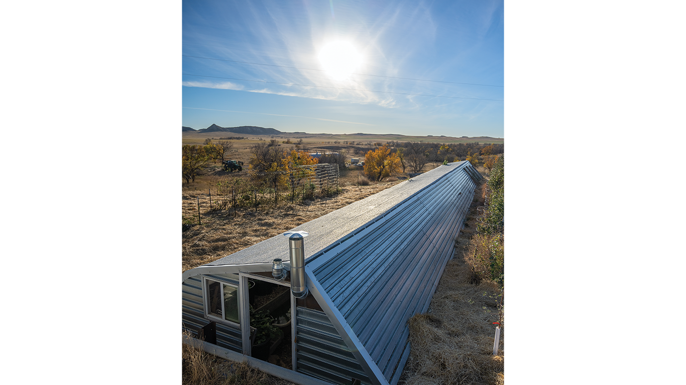 Long greenhouse under bright sun; rural landscape