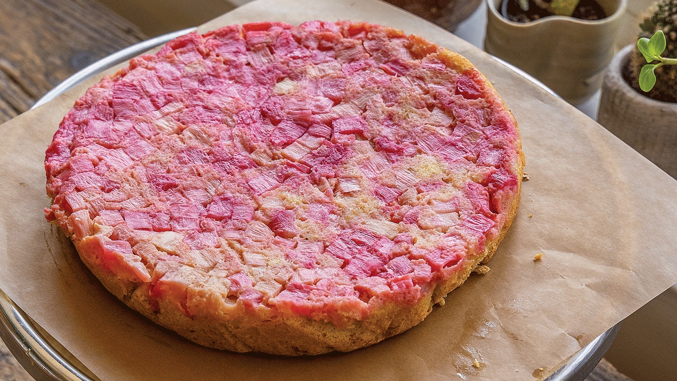 Dessert rose sur papier parchemin posé sur une table en bois près de la fenêtre/plantes