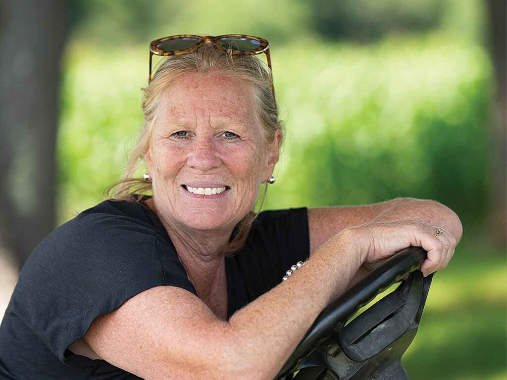 A close up of person smiling while driving a tractor