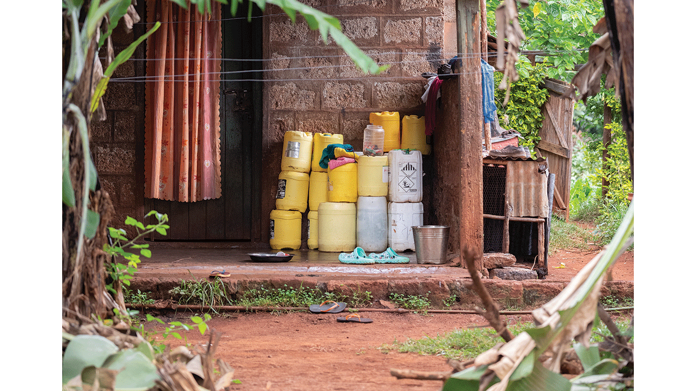 Stacked yellow and white plastic containers sit outside a small brick building.