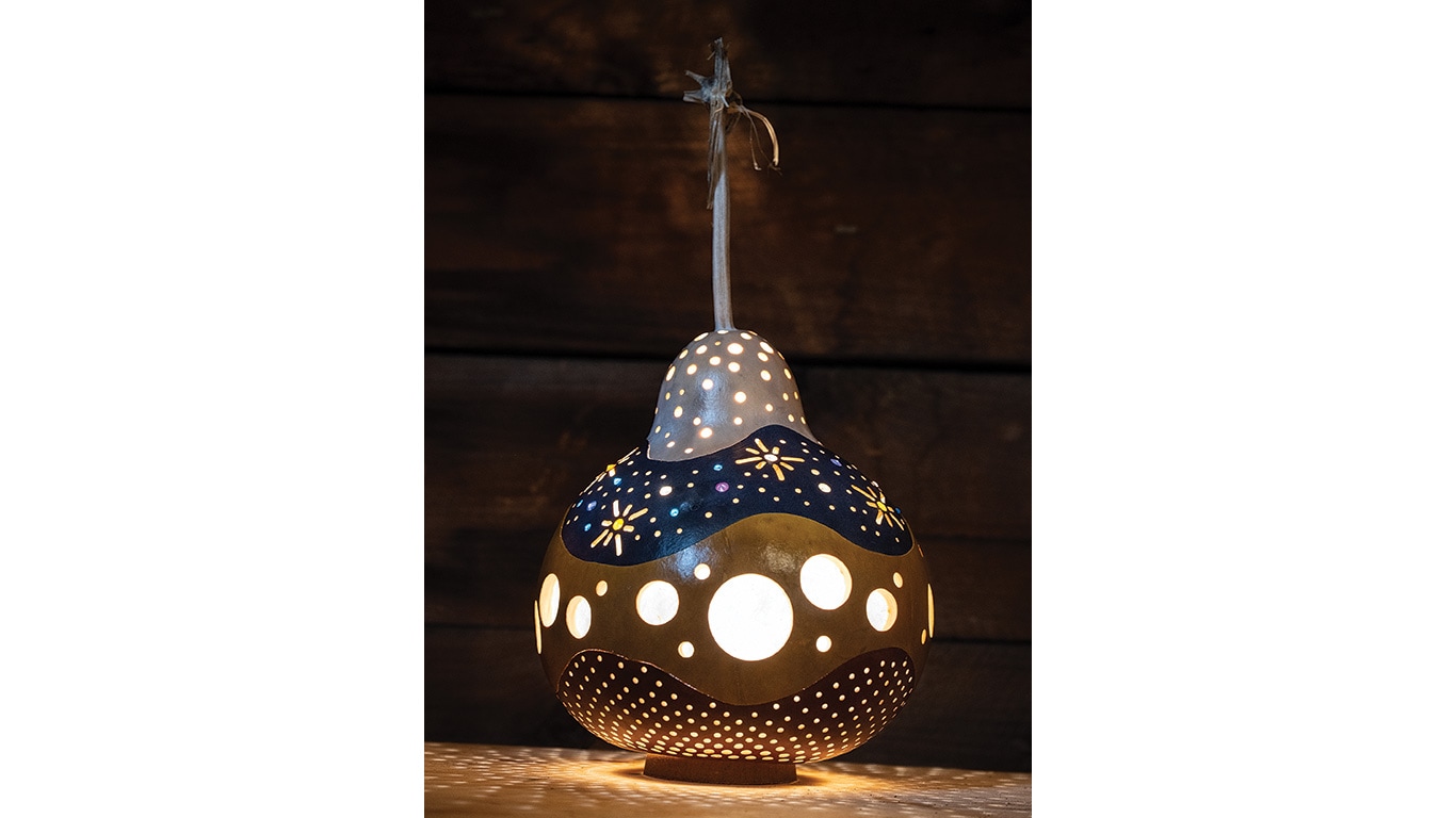 Hanging gourd lantern glowing with cut‑out patterns.