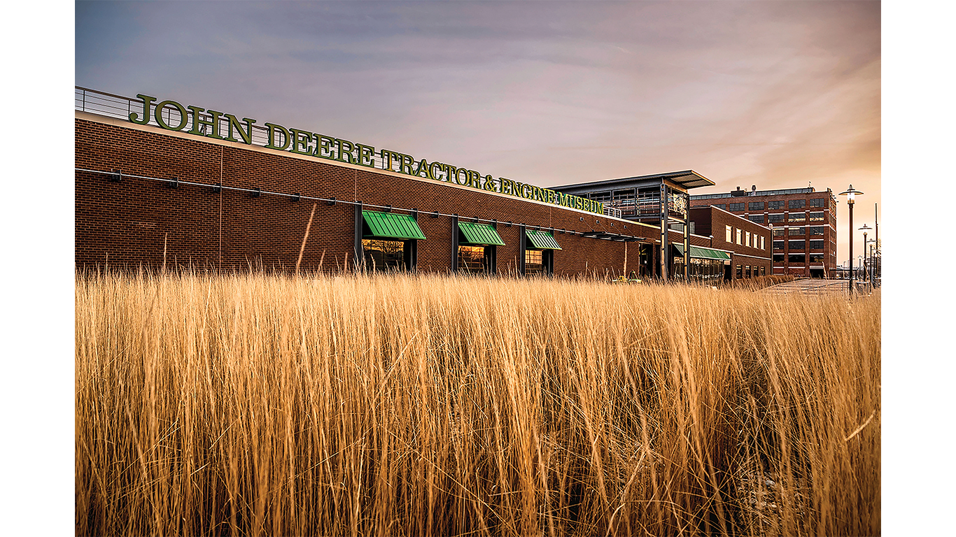 John Deere Tractor & Engine Museum building with tall grass in front during sunrise.