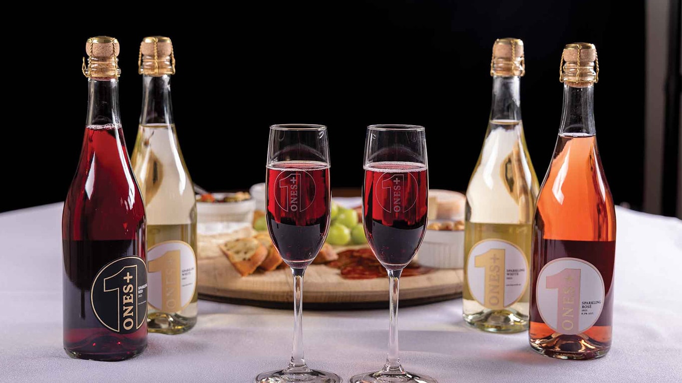 Bouteilles et verres de boissons pétillantes sur une table avec une planche de charcuteries.