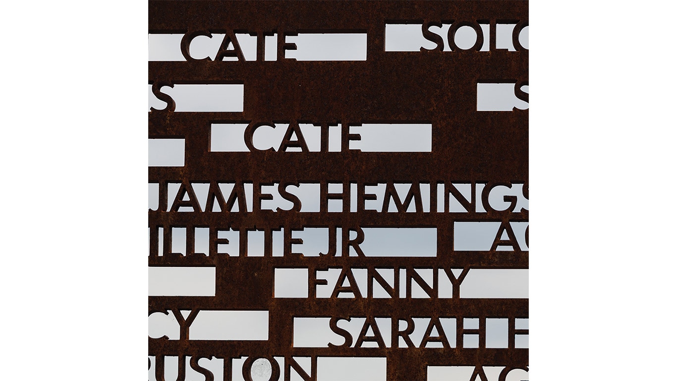 Metal panel with cut-out text showing partial names, including "James Heming" and "Sarah."